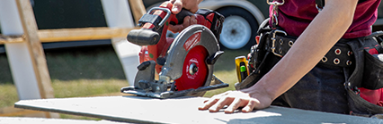 Apprentice student standing in front of saw horses using circular saw