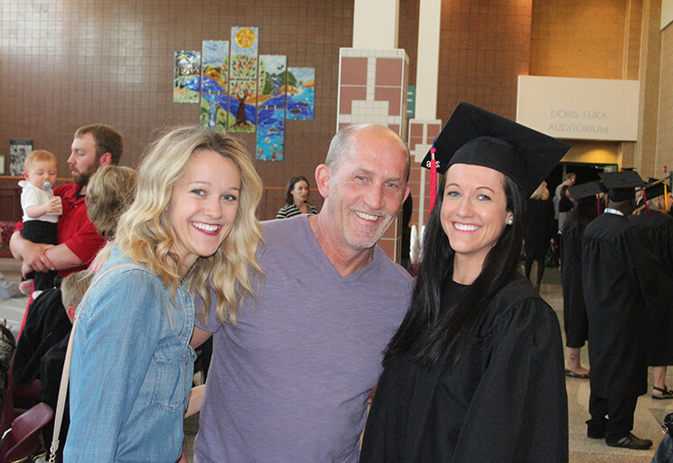 Smiling dad with graduate daughter