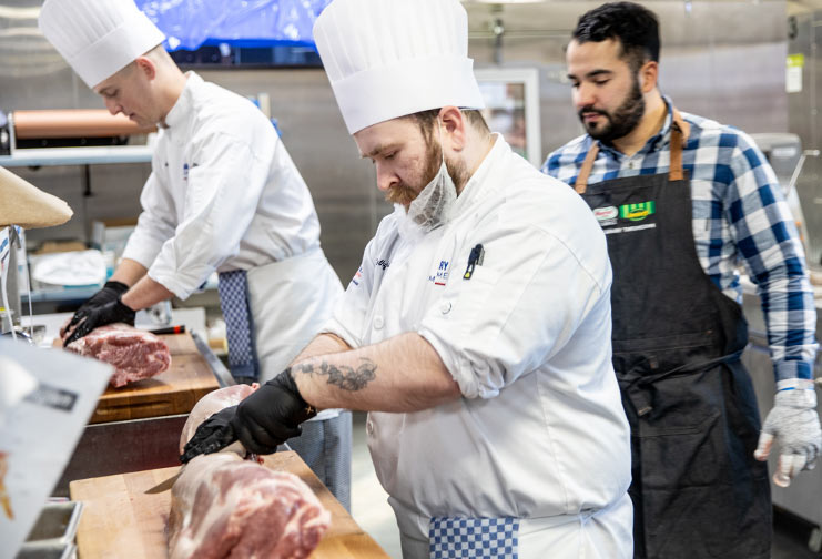 CVTC culinary management student learning how to butcher a pig.