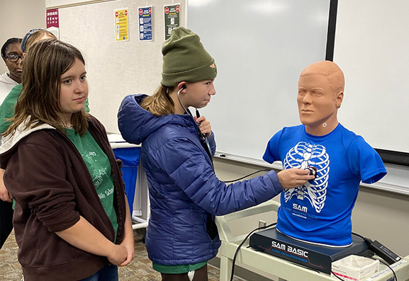 Students practicing with a stethoscope.