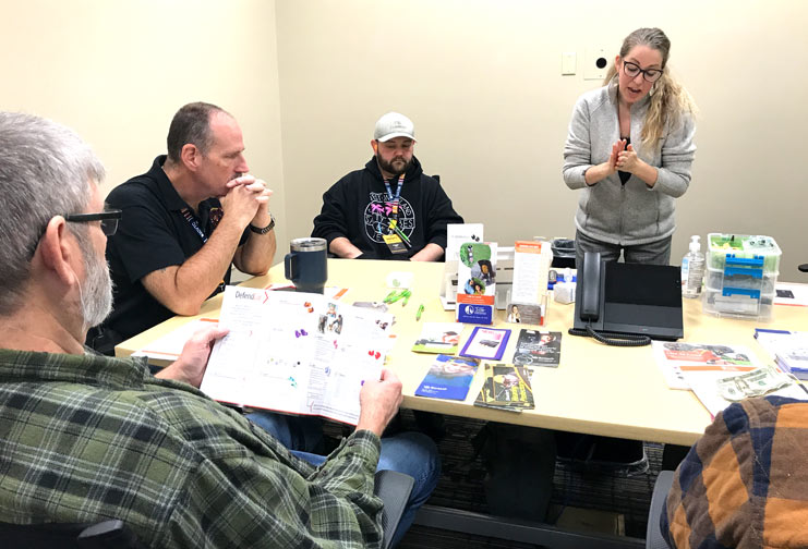 People around a table learning during safety conference.