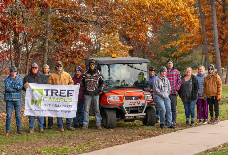 College students facing camera with trees in background