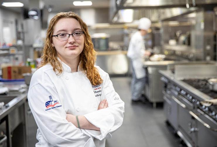 female chef in white coat in kitchen