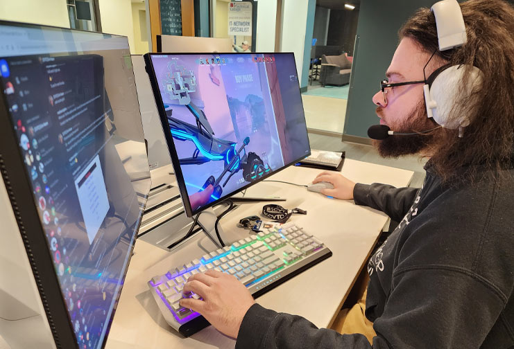 Man with headset playing esports in front of two computer screens