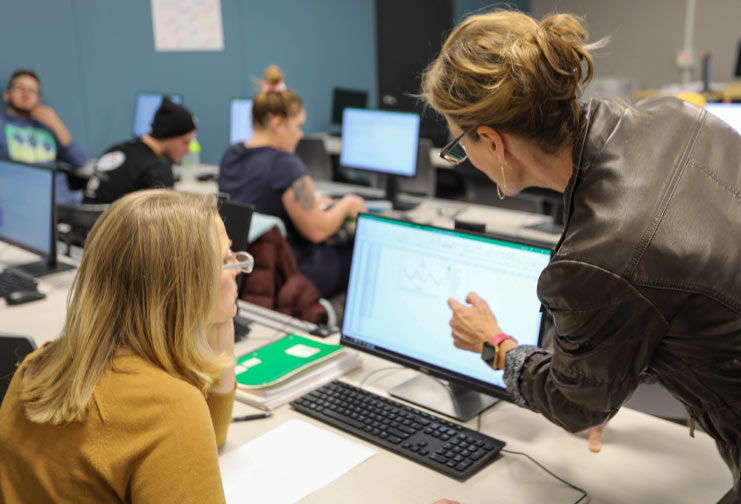 Female student and female instructor with a computer