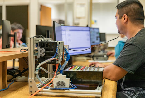 Student at a computer with box and wires