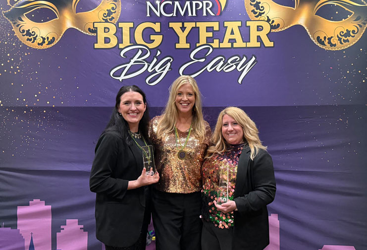 Three women in New Orleans holding an award
