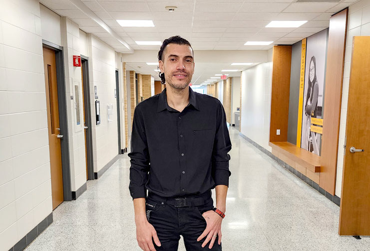 Man stands in college hallway wearing all black