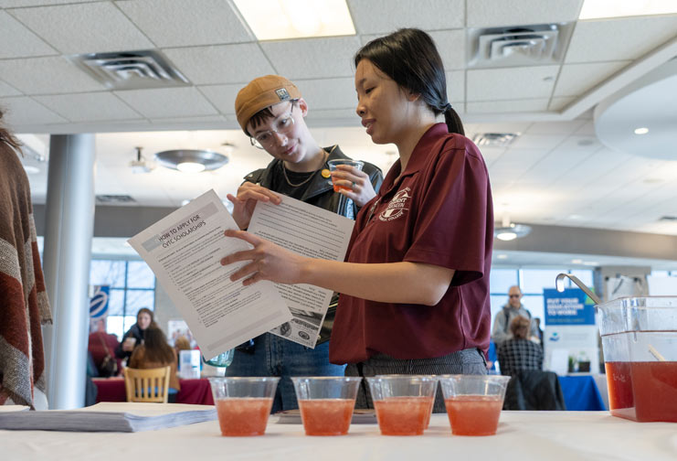 Woman at a technical college helping students learn about financial literacy.