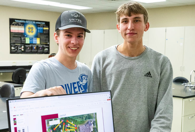 Two male students show off their disc golf course design on the Chippewa Valley Technical College campus.