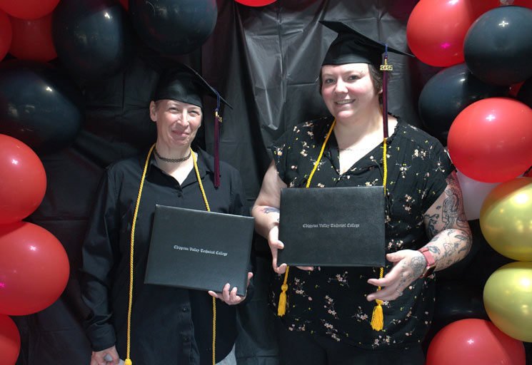 Mother and daughter in caps with diploma covers