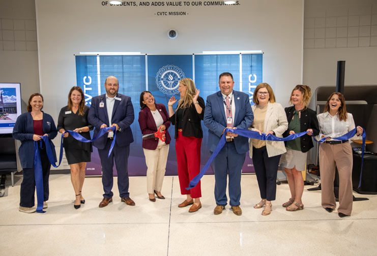 College administrators cutting a ribbon for a refreshed building.
