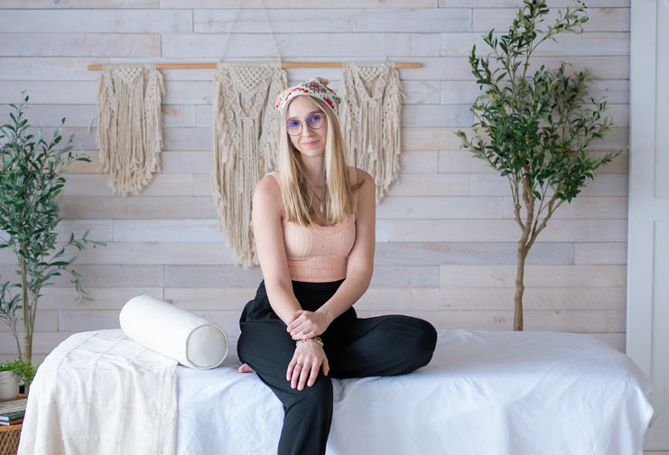 Woman sitting on a clinical bed in her holistic healing center