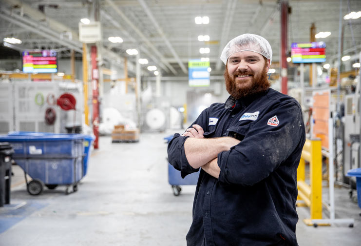Drylock male employee in hair net and smock on the manufacturing floor in Eau Claire, WI.
