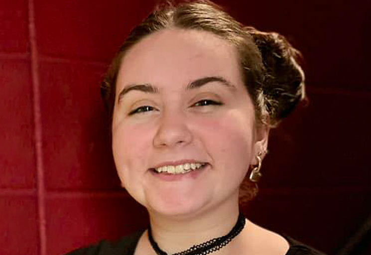 Female with brown hair against a red background