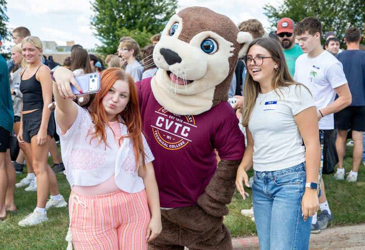 Ollie and two female students shown during New Student Welcome Day.